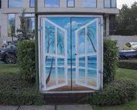 A street electrical box decorated with a picture of a window opening a view to an ocean-like background